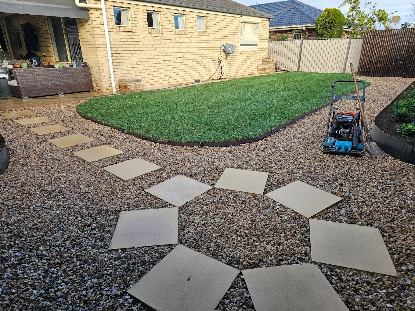 Backyard makeover with diamond-set concrete pavers in crushed rock and a freshly laid turf lawn