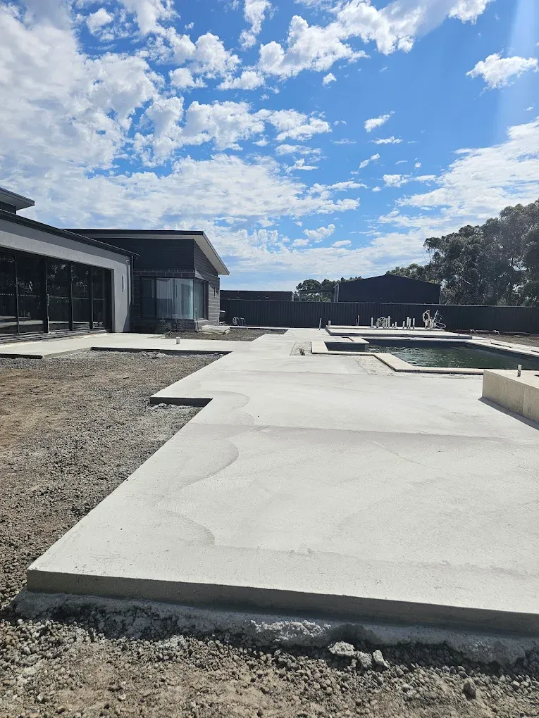 Large freshly poured concrete slab and paths at a new build on a big block